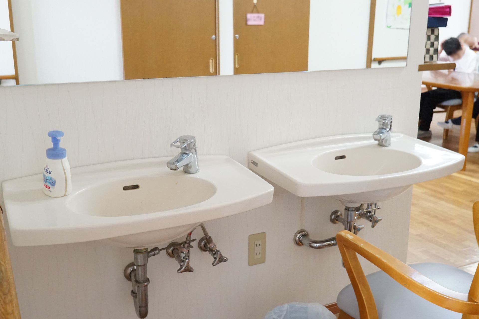 介護車両の前にいる車椅子に乗った高齢者と介助をするヘルパー