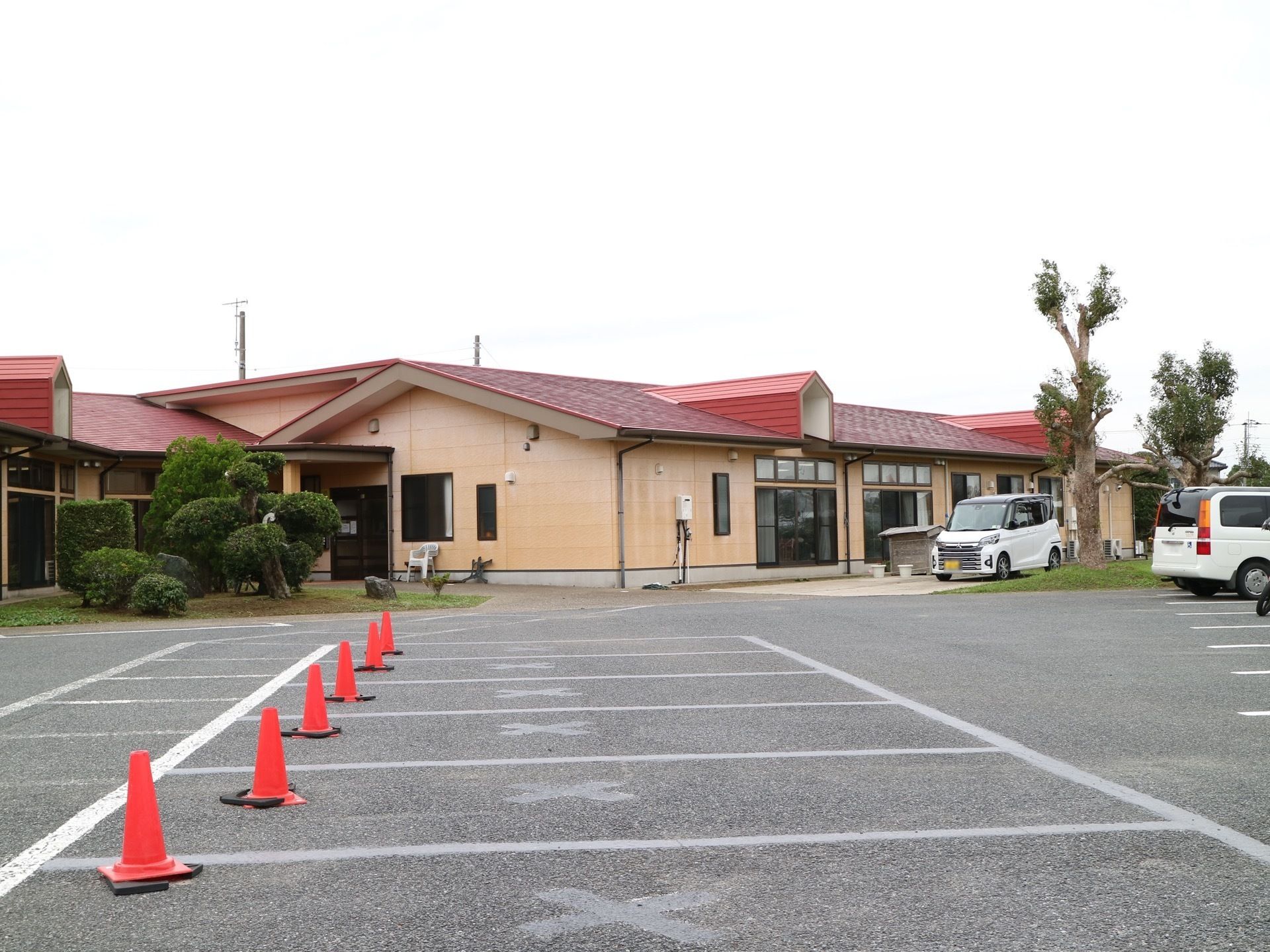 施設の外観は赤い屋根が特徴の、丈の低い建物となっている。駐車場は複数完備されており、ゆとりを感じさせる。