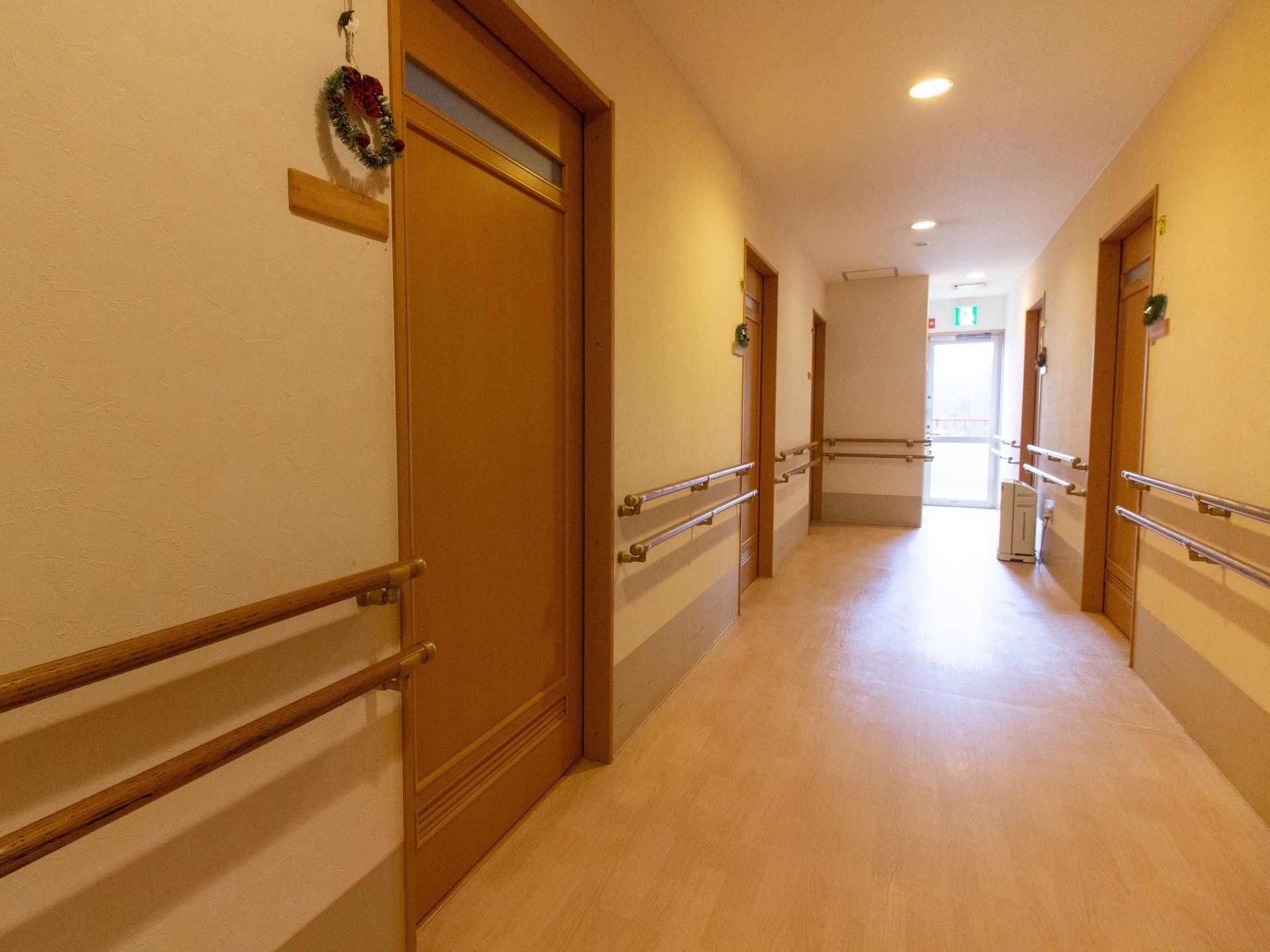 きれいに清掃され、広い横幅を設けた廊下である。通路に沿って、腰高の位置に２段の手すりが設置されている。