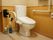 トイレには、洗浄機能付温水便座が設置され、両脇には手すりが取り付けられている。床には、便座脇に除菌スプレーや消臭スプレーなどが置かれている。