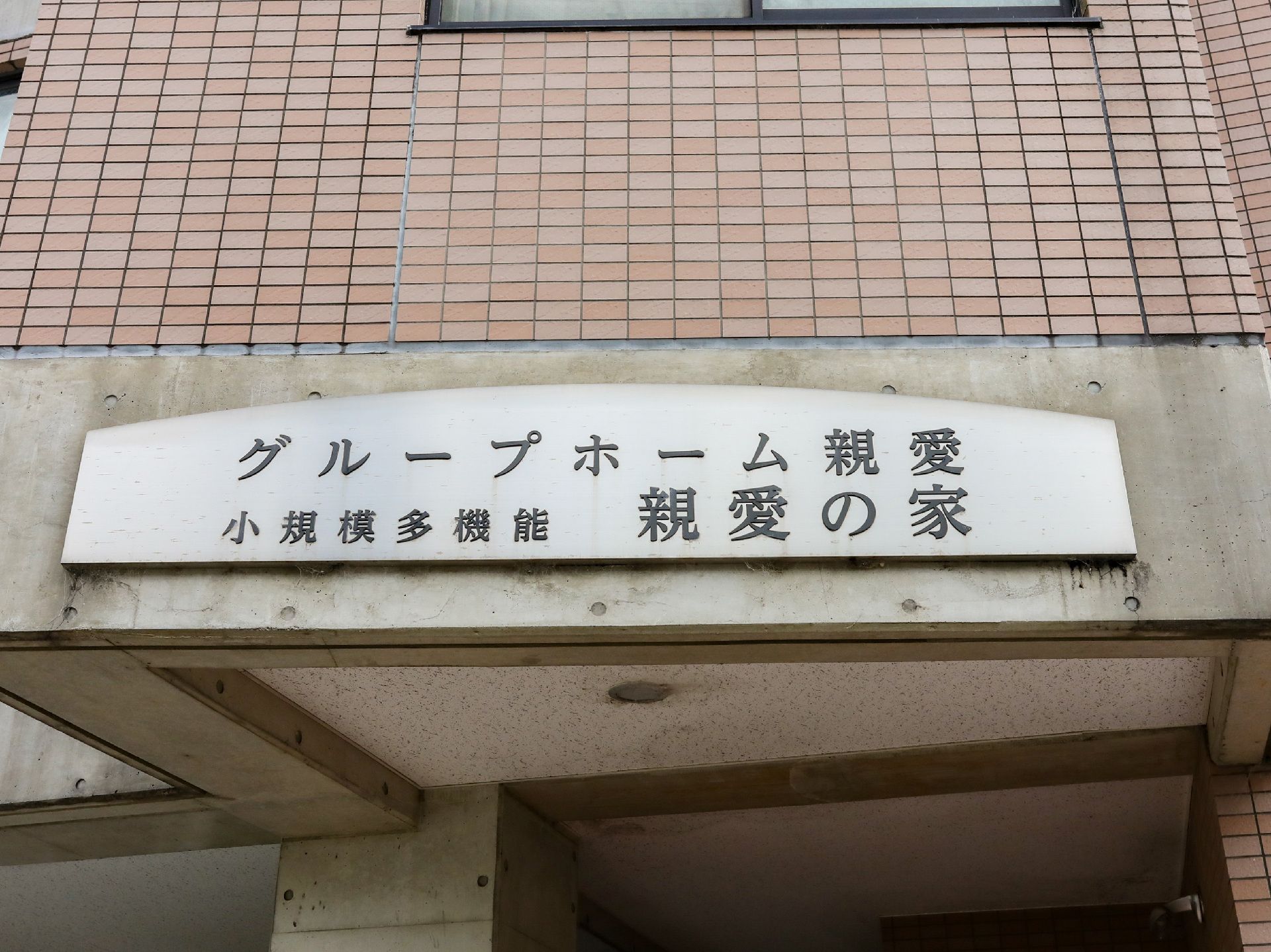 玄関の天井付近に設置され、施設の名称が書かれている木の看板