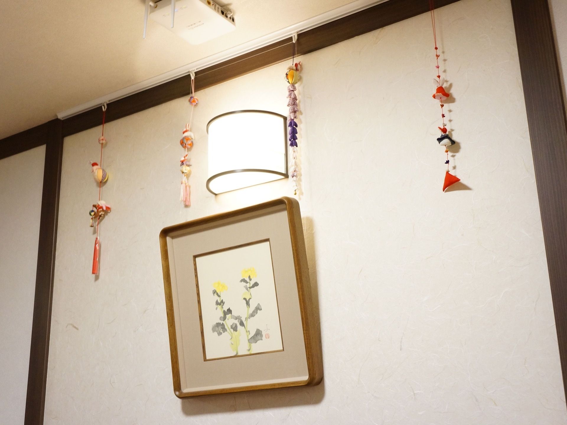 壁には照明が設置され、黄色い花の絵が飾られている。天井からはちりめん生地で作ったカラフルな装飾物が吊るされている。