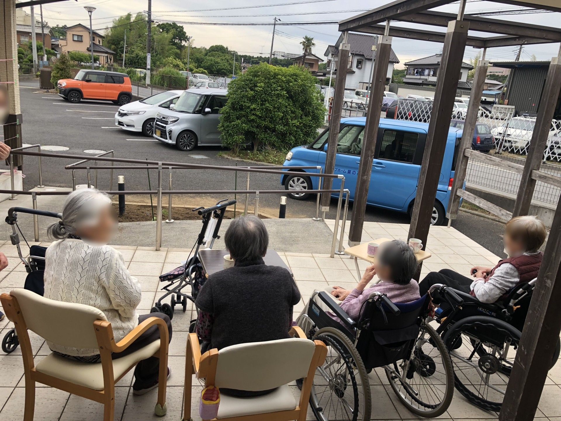 椅子に座りエントランスでお茶会をする入居者さま