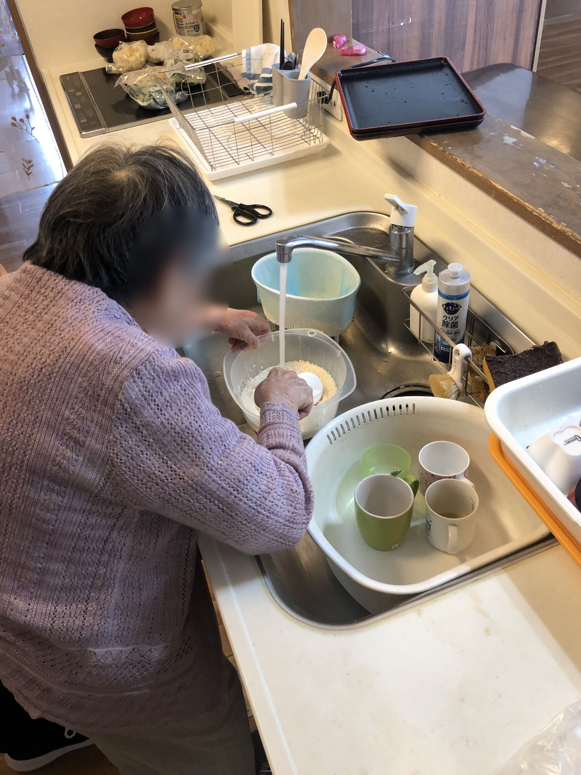 キッチンで米を研ぐ女性