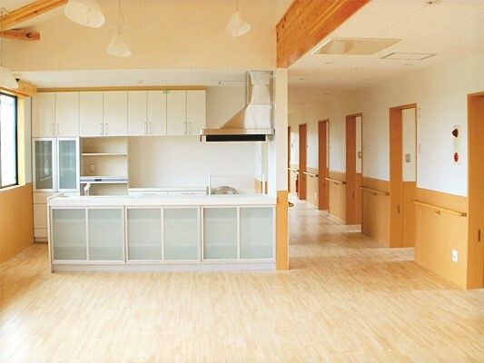 食器棚や収納棚がたくさんついた対面式のキッチンが正面にあり、右側には居室のドアが並んでいるまっすぐな廊下がある。