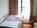 寝具付きのベッドが置かれた部屋にはエアコンが付き、カーテンが付いた窓も設置されている。