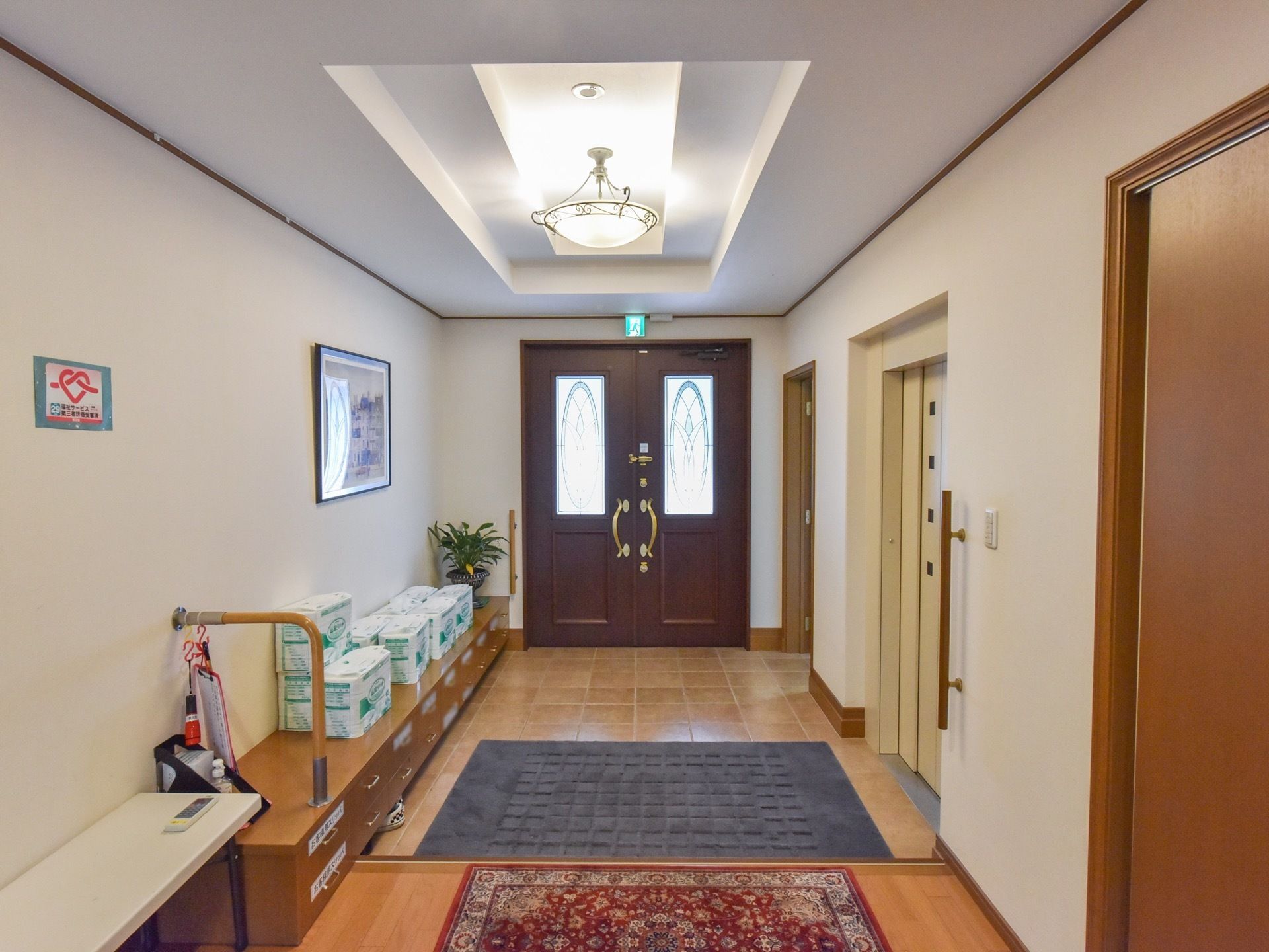 木製の玄関ドアは観音開きで、土間部分は広い。シーリングシャンデリアが取りつけられている。オリエンタル風の玄関マットが敷かれ、お洒落である。