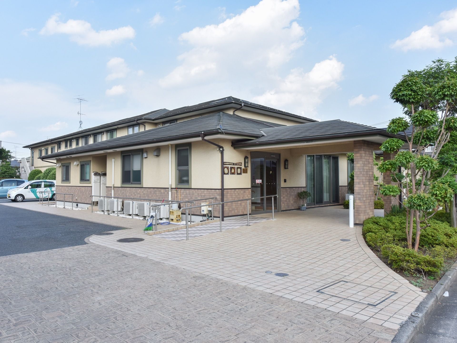 車寄せのあるエントランスには木々が植えられており、高級感のある外観となっている。駐車スペースも十分に確保されている。