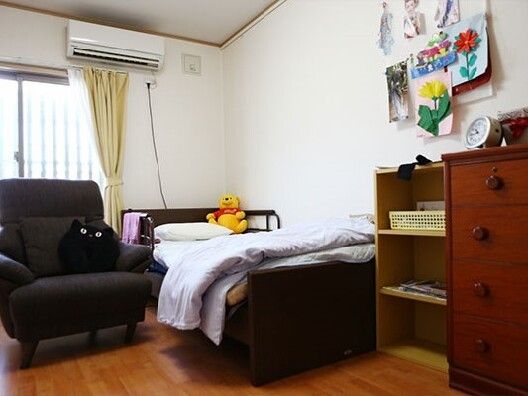 ぬいぐるみが置かれた寝具付きのベッドが置かれ、タンスや棚、寝具付きのベッドが置かれ、一人用のソファもある。