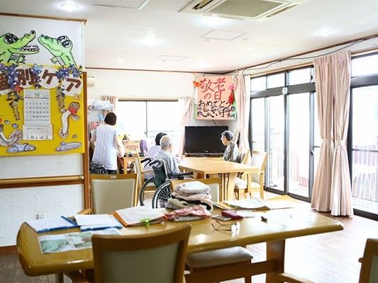 二面採光性の明るい室内。高齢者とスタッフが談笑している様子