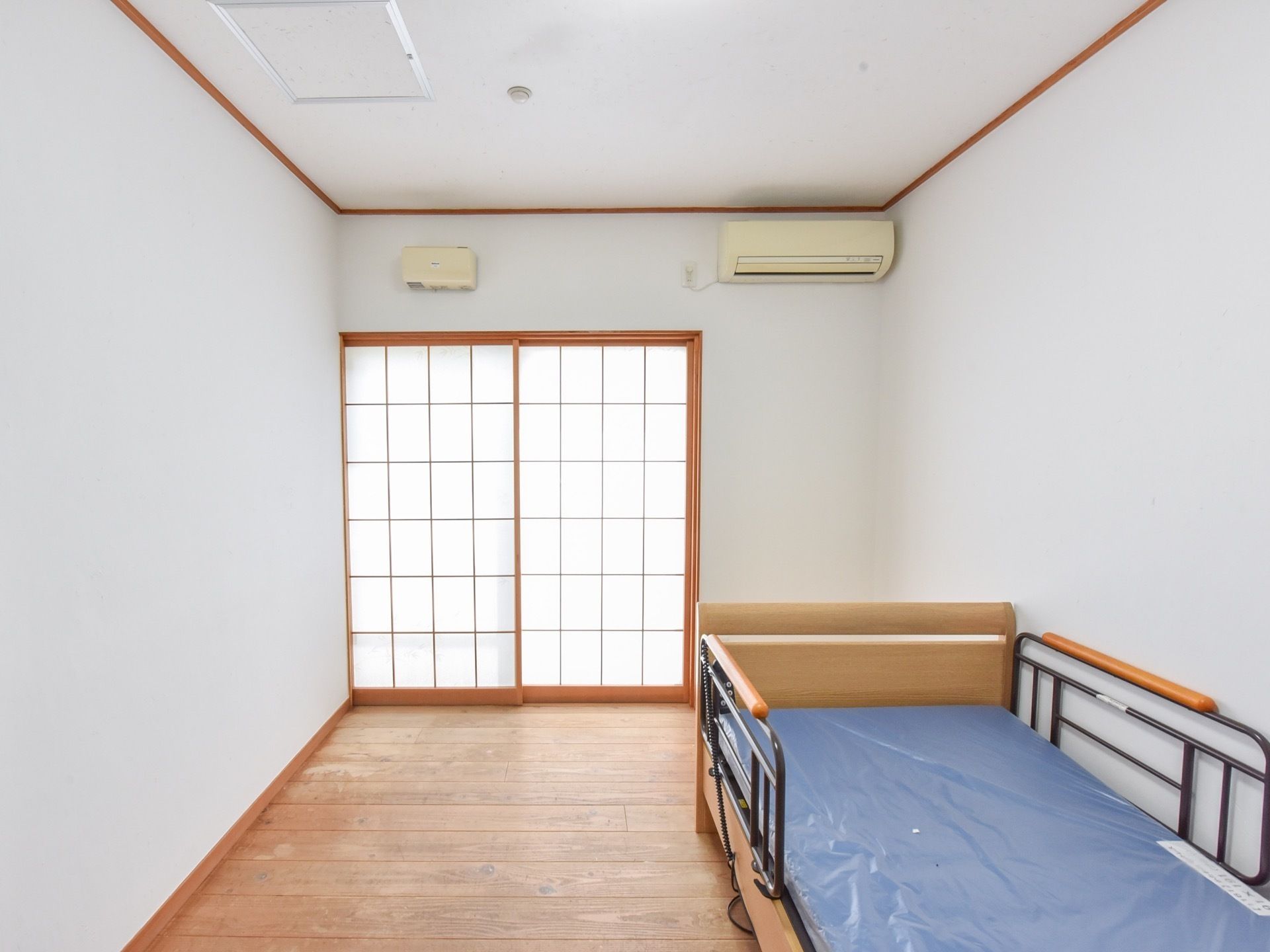 自分の部屋で新聞を読んでいる高齢者。コーヒーを手元において真剣な様子で見ている。自分の部屋でのんびりしている様子。