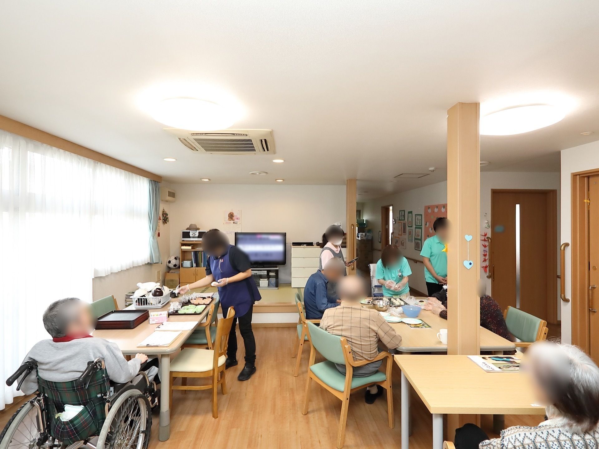 リビングで料理を作るレクリエーションを楽しむ高齢者とスタッフ