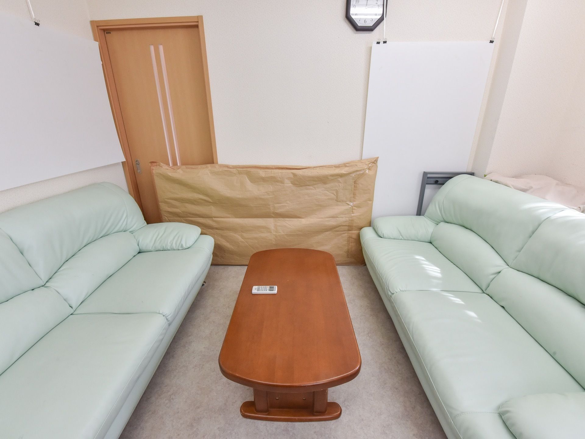 車いすに乗る高齢者とそれを押す人。こちらを見て頬電でいる様子
