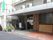 屋根が付いた玄関先には草木が植えられている鉢がたくさん置かれ、ドアにはホーム名が書かれている。