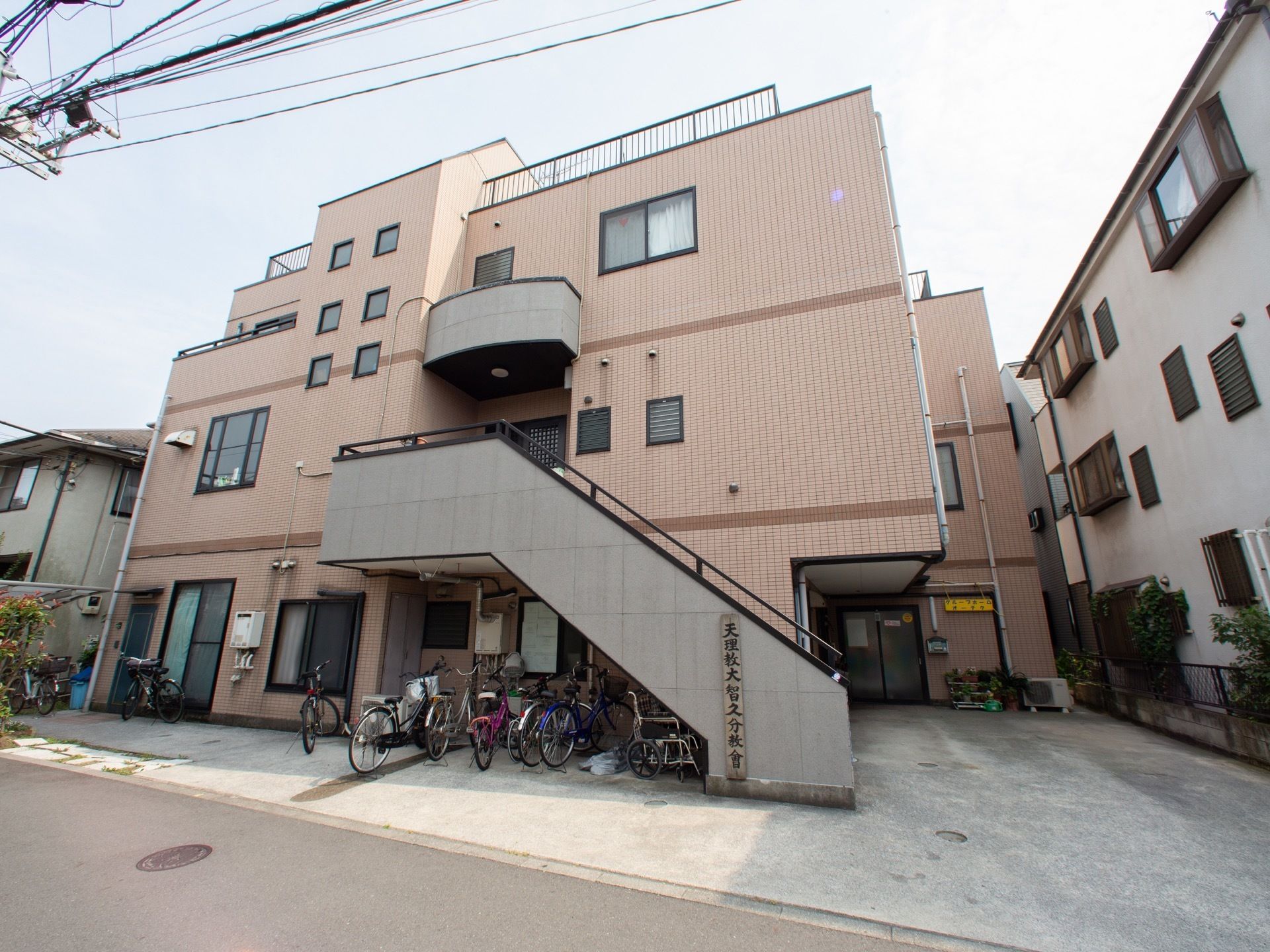 施設は明るいレンガ調タイルの３階建ての建物である。コンクリート造りの外階段の下は、駐輪場となっている。