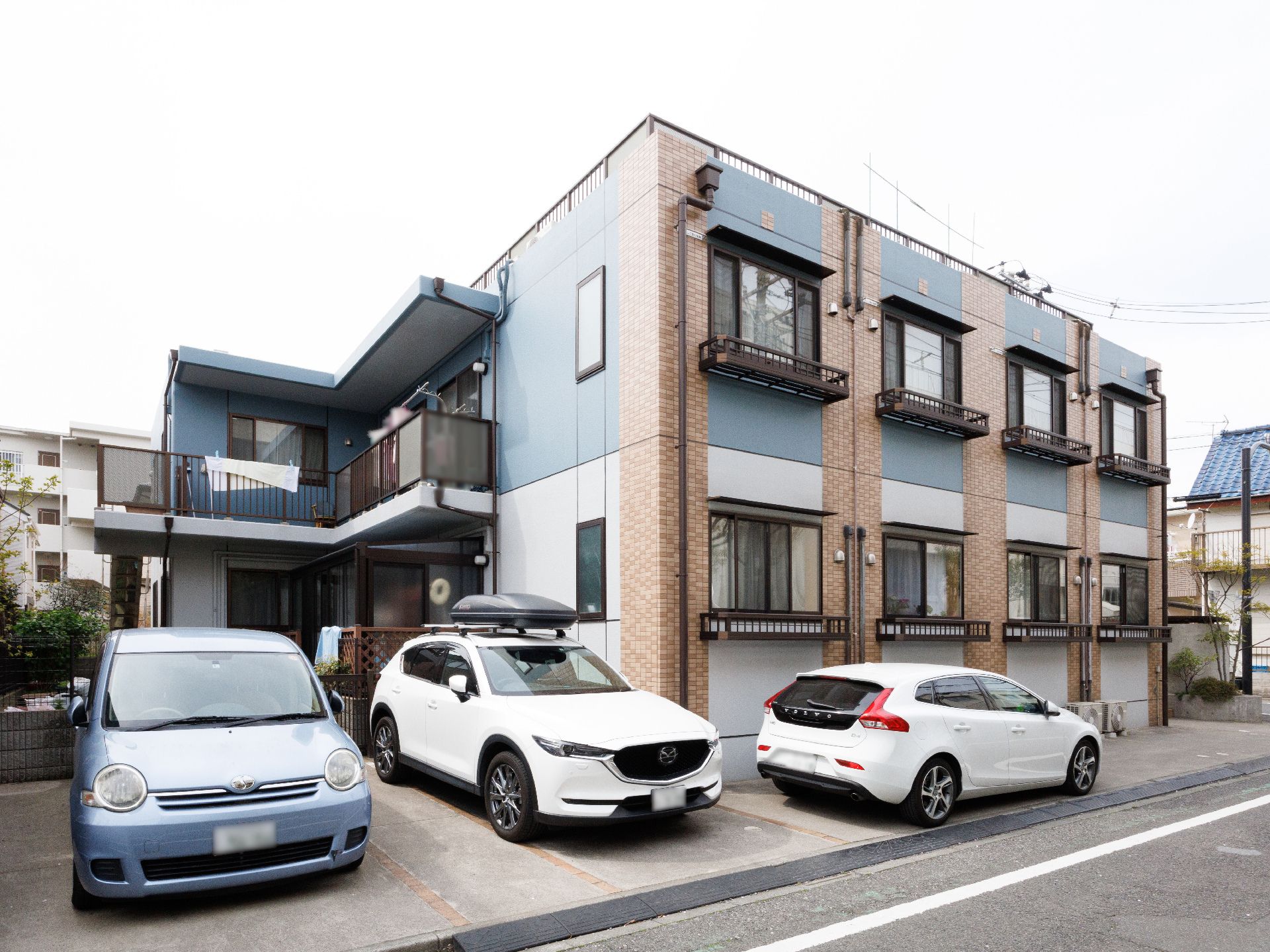 2階建ての建物。日当たり良好で敷地内には駐車場も完備され、建物の一番上にはバルコニーがある。
