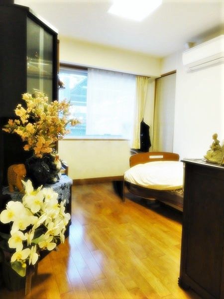 大きな窓があり明るい雰囲気。居室にはベッドや収納家具だけでなくエアコンもついている。