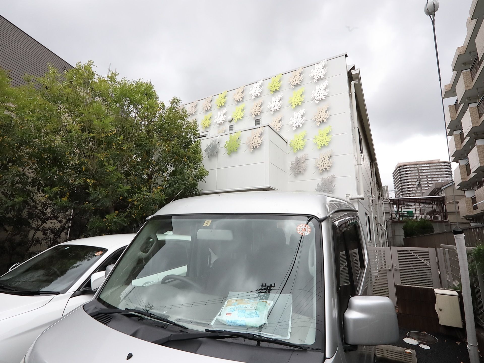 施設周囲は防犯のため、フェンスや生垣などで囲われている。敷地の裏には、駐車スペースも用意されている。