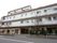 施設の建物は、１階の部分は駐車場になっている。建物側面の中ほどに駐車場の入口があり、中に車が停まっているのが見える。