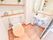 左手のトイレには便座カバーがかけられ右側に手すりが設置されている。壁際に大きめの鏡と棚があり流しもついている。