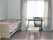 段差のない居室にはベッドやいす、ベンチなどが置かれ、大きな窓にはカーテンが付けられている。