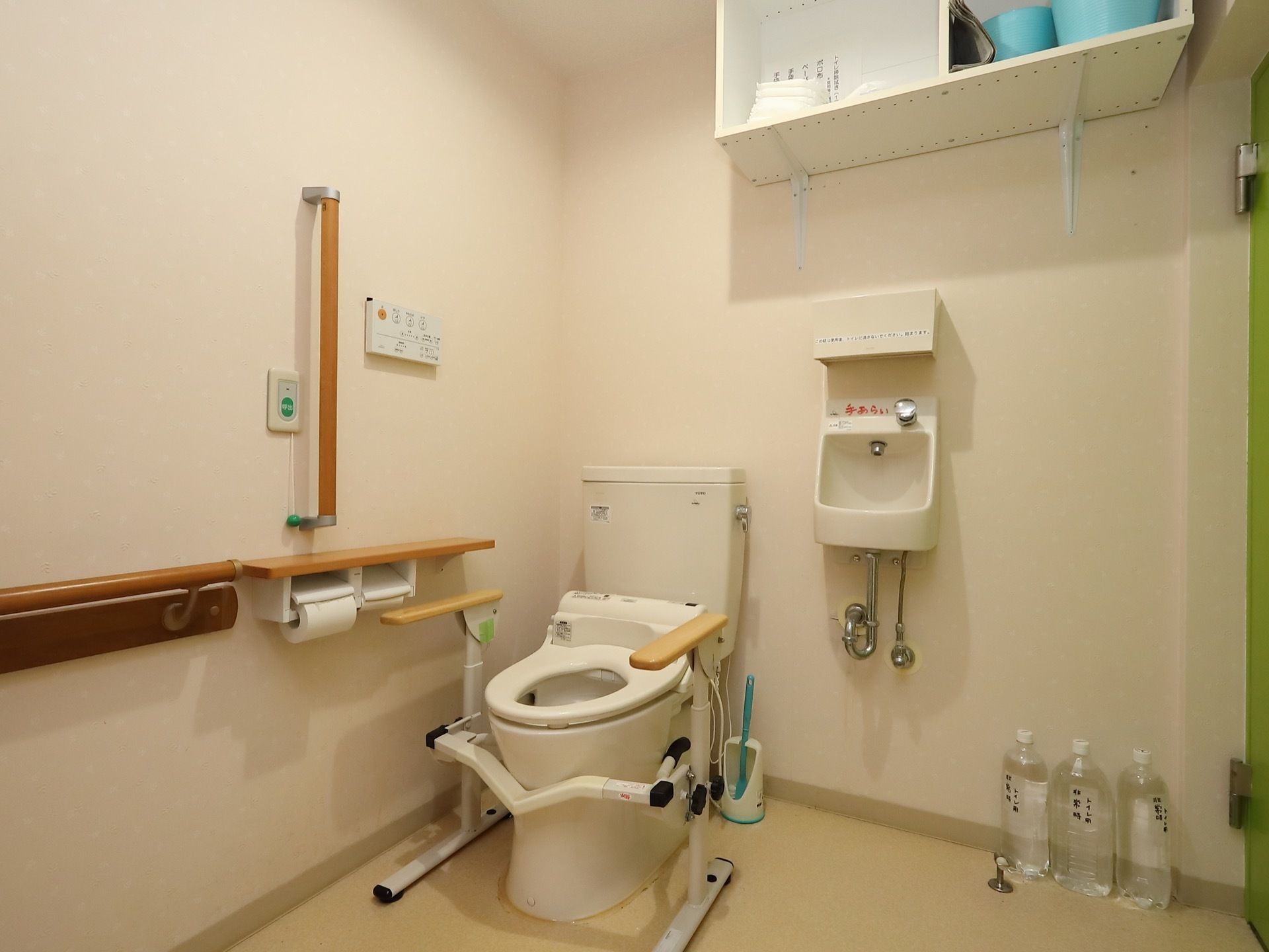 トイレは洗浄機能付きで、便器の周囲には複数の手すりが取りつけられている。壁にスタッフ呼び出し用のボタンが設置されている。