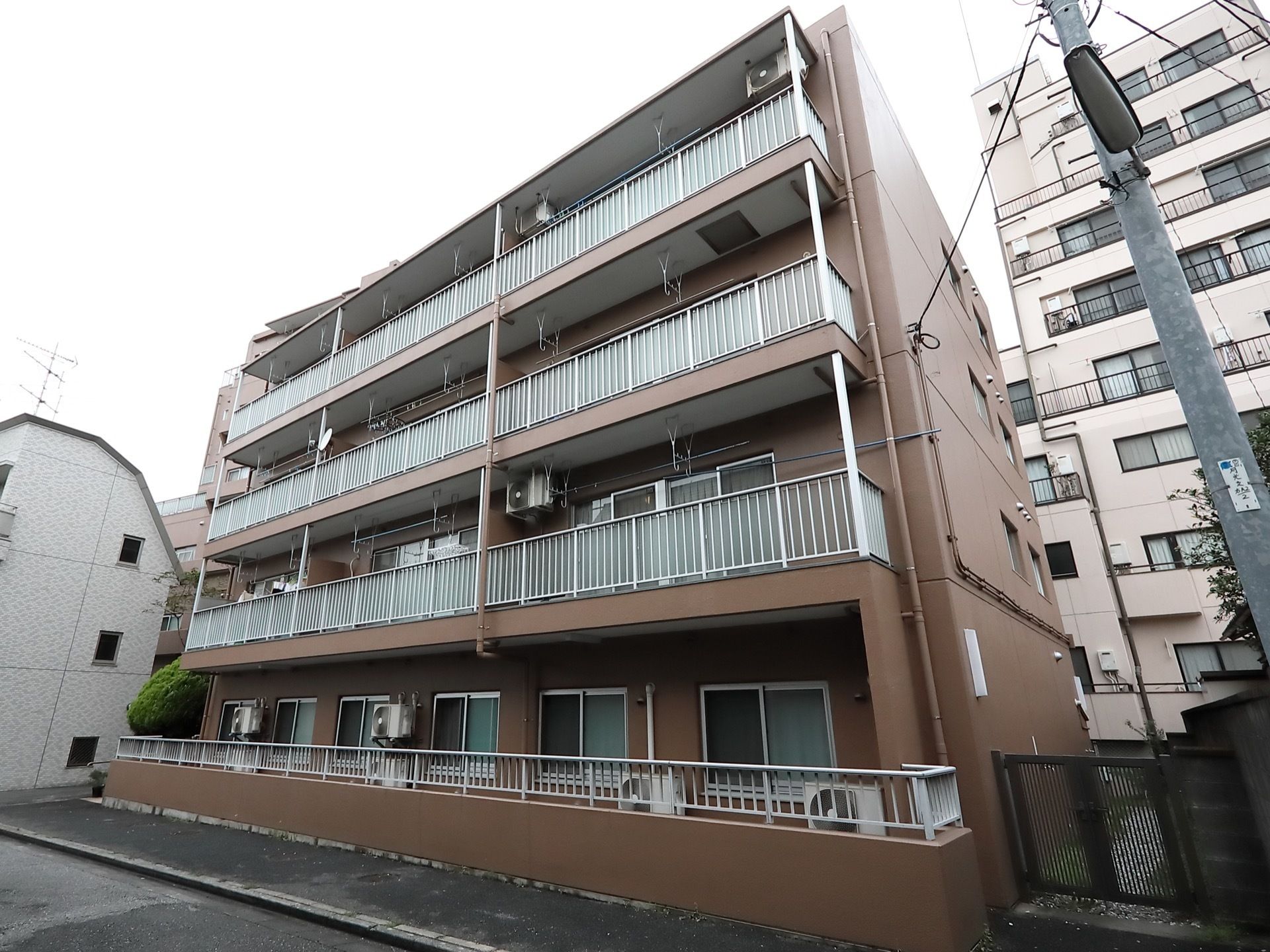 深い茶色の４階建ての四角い建物である。建物外周にはコンクリートの壁と門が設置され、周囲にも高い建物が複数ある。