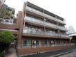 ４階建ての茶色の建物である。各階にベランダが設置されており、エアコンの室外機も置かれている。周囲には、木が植えてある。