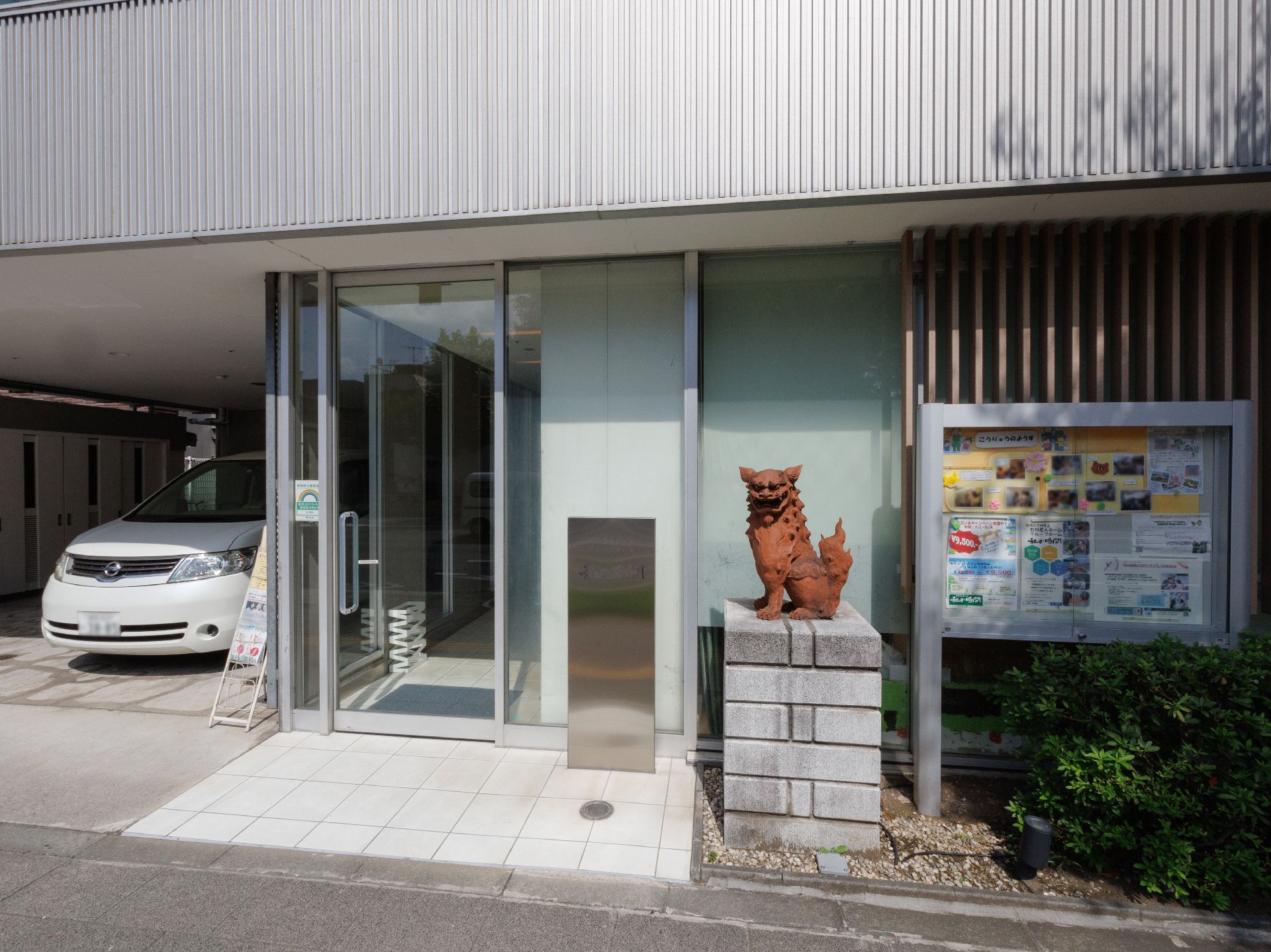 ブルーのエプロンを付けた女性スタッフとジャケットを着た高齢女性が屋外を散歩している。