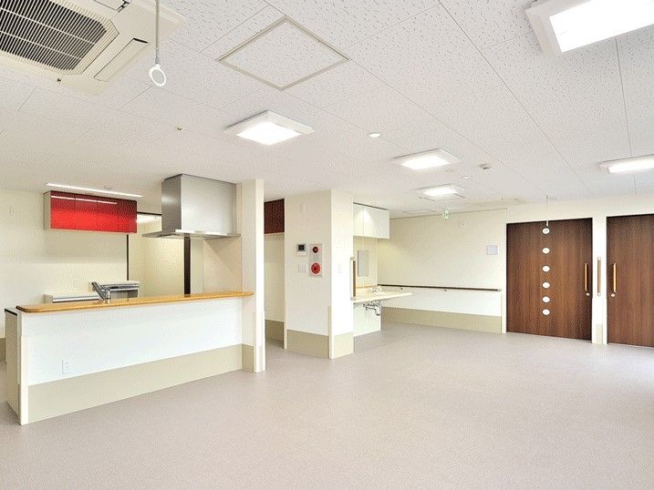 白を基調としたキッチンには赤い収納棚が付き、対面式で、フロアには家具はまだ置かれていない。