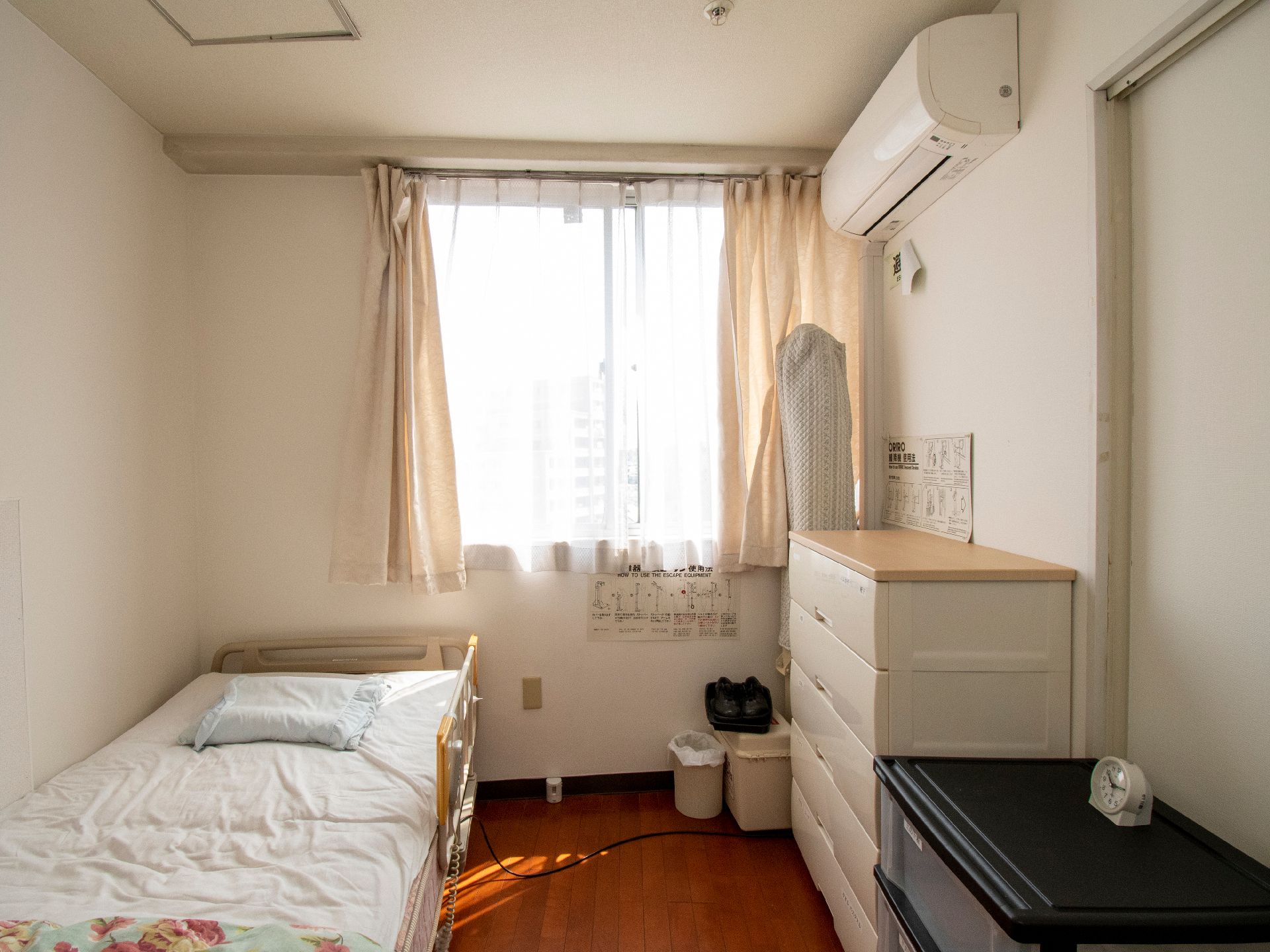 ベッドと白い棚が置かれた白い壁の部屋