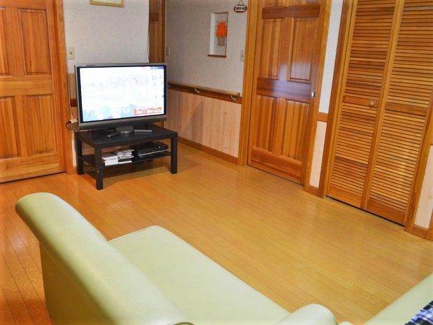 ソファやテレビが置かれたフローリングのスペース。ほかに家具はなくシンプルな造り。