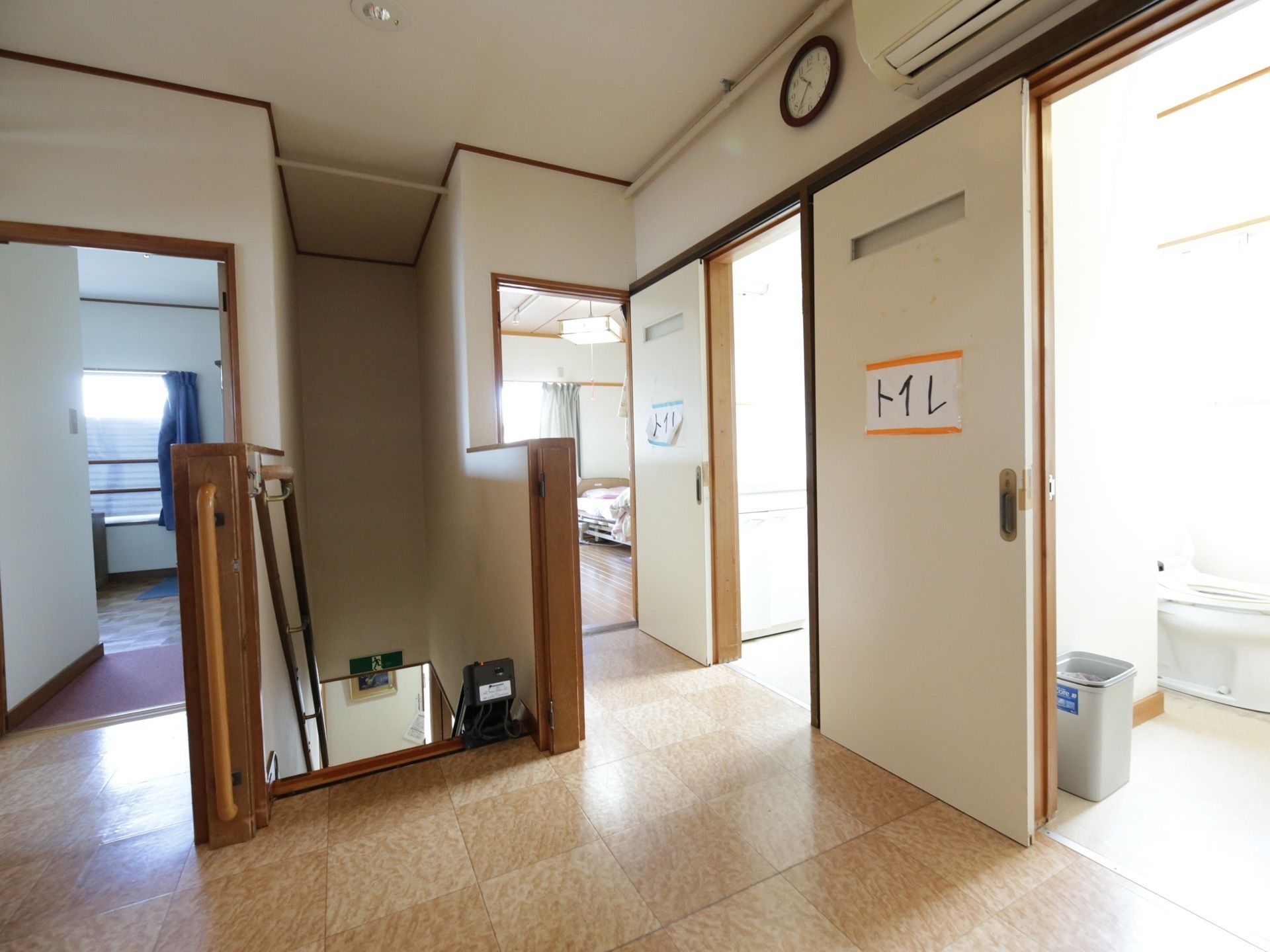階段を上がるとビニール床の廊下がある。２カ所あるトイレは引き戸が付いている。壁にはエアコンが設置されている。