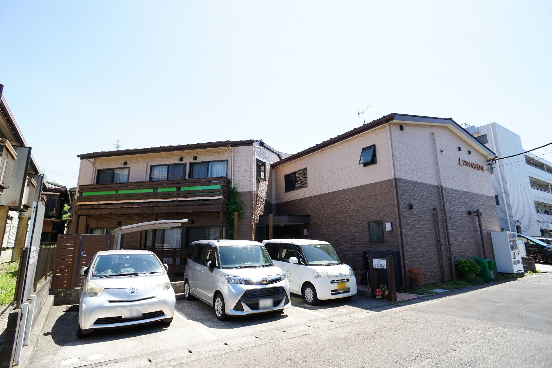 2階建てで、茶色の落ち着いた色合いが特徴の施設の外観