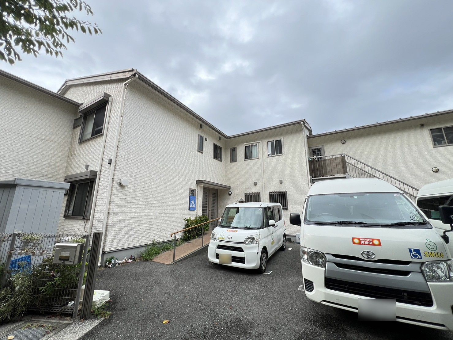 2階建ての建物は１階部分がベージュ、２階部分がダークグレーで建物の外壁委はホーム名が書かれている。高い台にあり、日当たりも良好。