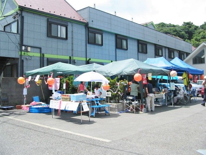 緑のタープがたくさん設置され、風船や手作りの看板で飾り付けがされている。