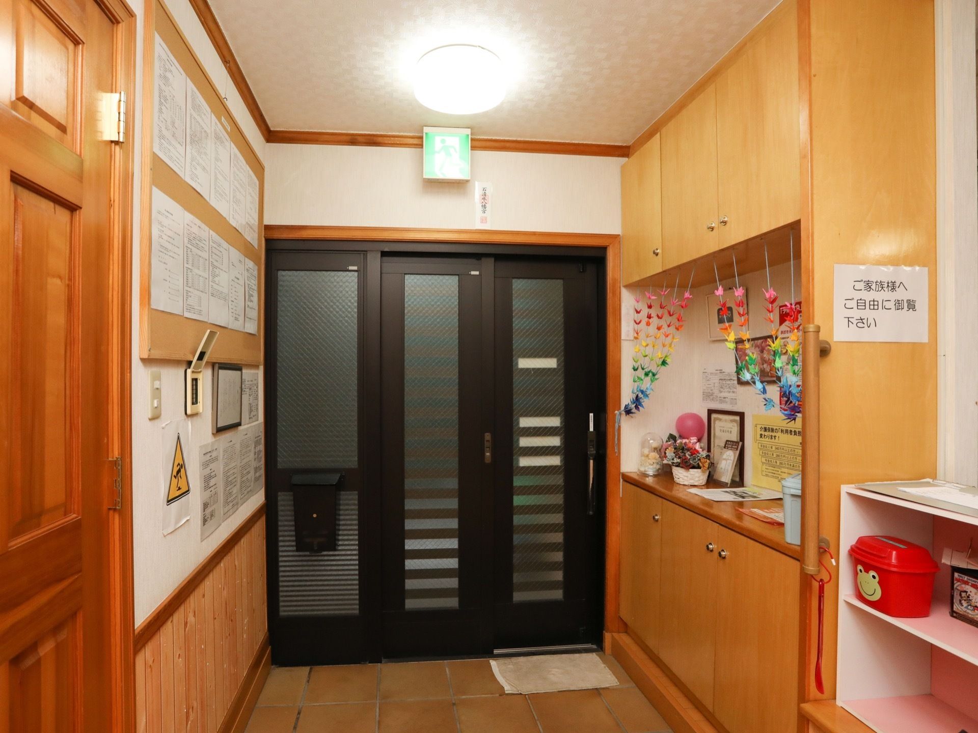 木目調のドアや靴箱で、木のぬくもりが感じられる玄関。黒の枠組みにすりガラスのドアはスライド式で、左側に郵便受けが設置されている。