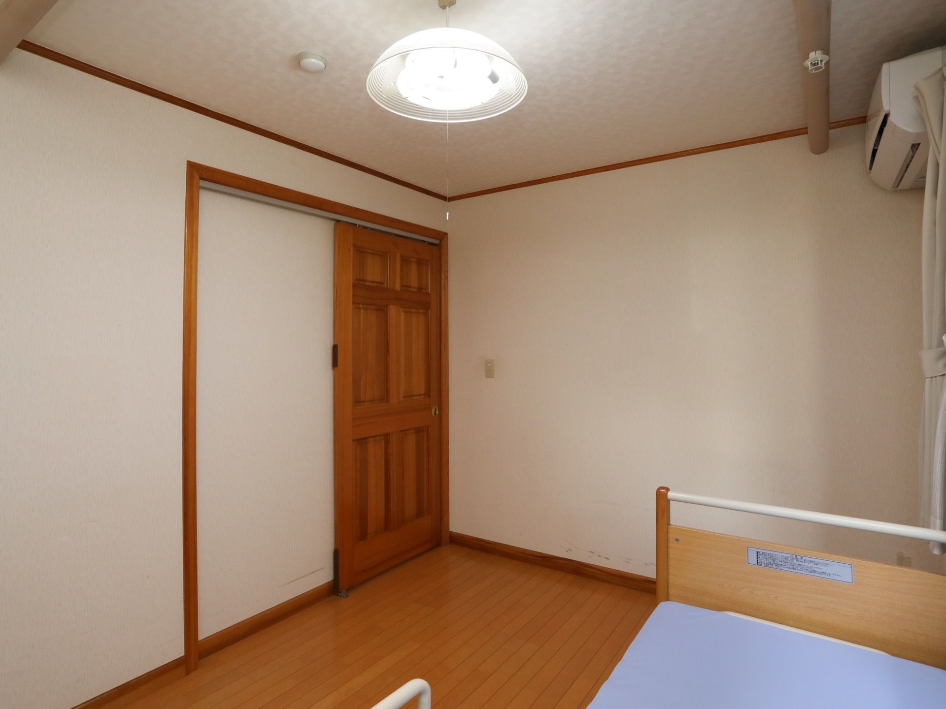 居室のライトは蛍光灯が設置され、紐で点灯、消灯が行えるようになっている。ドアは木目調で引き戸である。