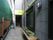 建物に沿って、細長い通路が伸びている。通路の奥には、玄関があり、途中にはプランターに植えられた植物が置いてある。