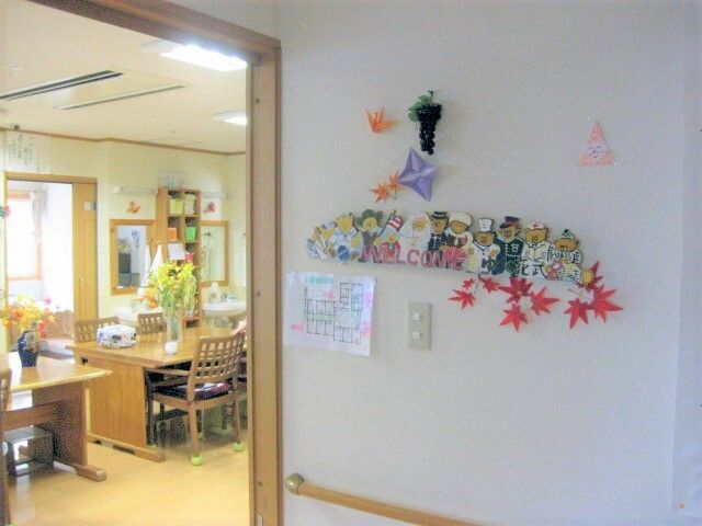 施設内の壁に取り付けられた飾りの様子。奥の方にリビングがあるスペース