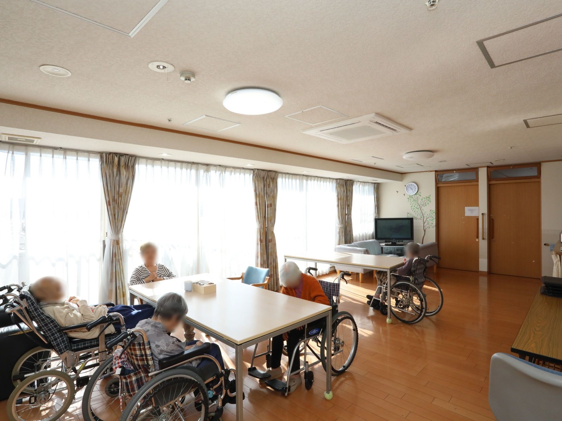 柱などがなく、開放感がある共有スペース。テレビ、ダイニングテーブル、椅子、ソファーが設置されている。
