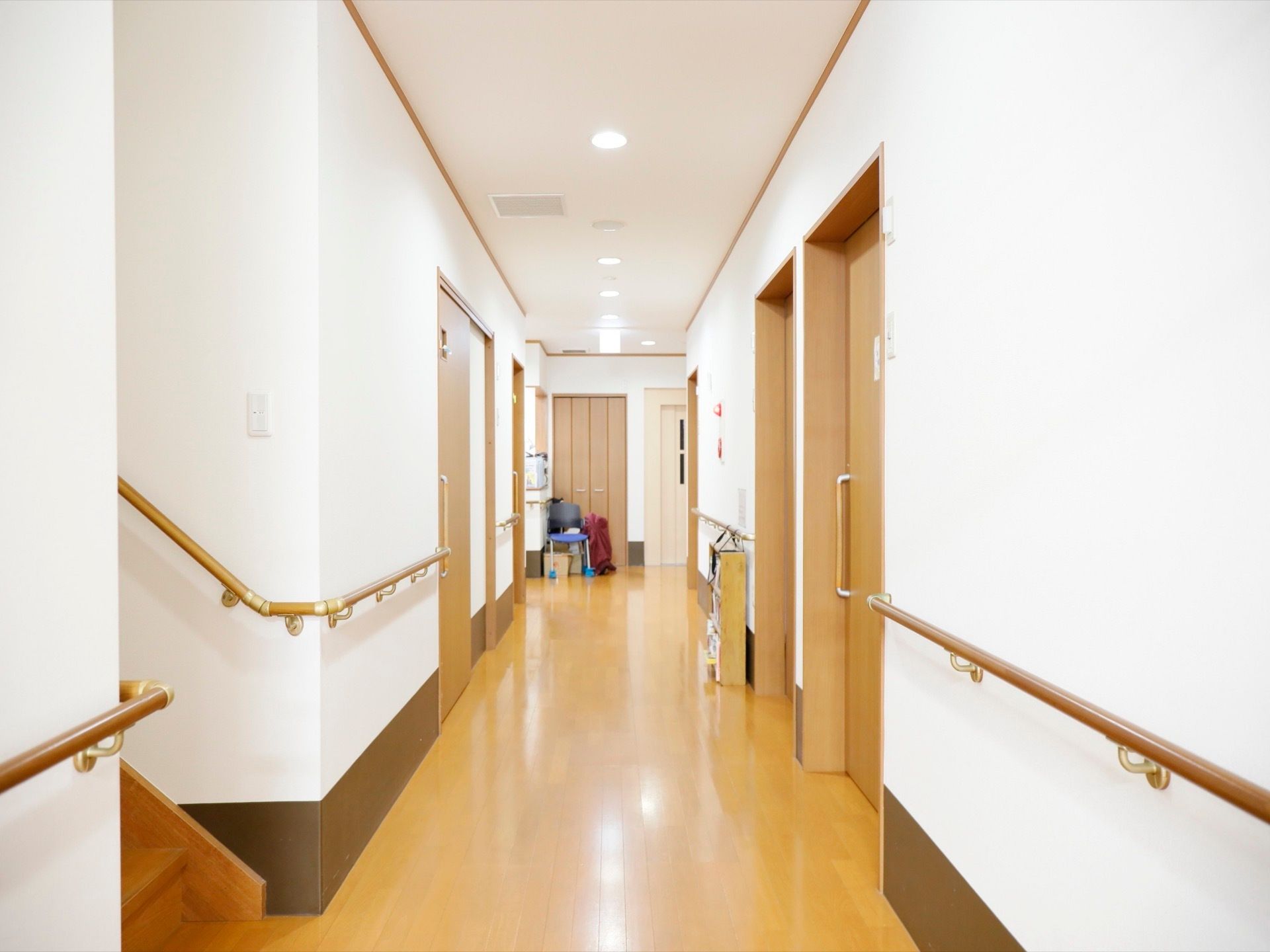 白い壁が明るい雰囲気の通路である。手前の階段から、手すりが全ての壁に取りつけられている。また、王にはエレベーターが見える。