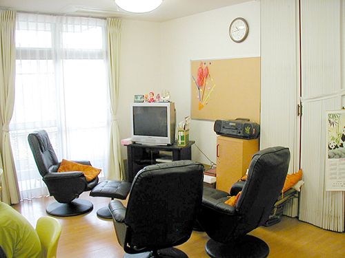 テレビが置かれたスペースには大きな窓があり、レザー調の椅子が複数置かれている。
