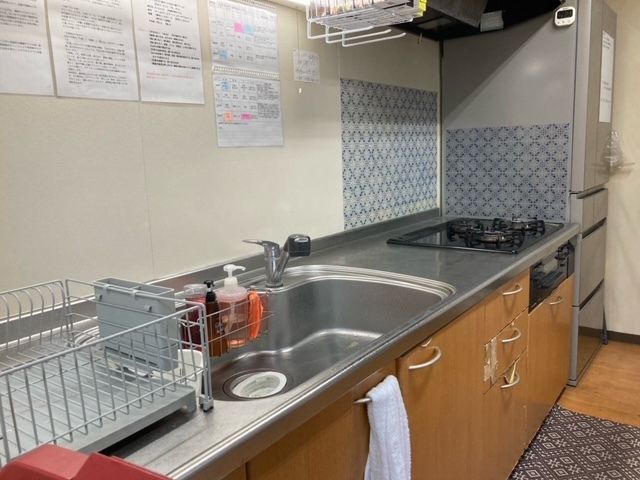 冷蔵庫が設置されたキッチンには調理器具などがあり、窓も付いていて明るい雰囲気。