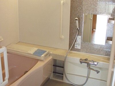 手すりや鏡、シャワーが付いた浴室には一人用の浴槽があり、一般的な家庭と似た環境。
