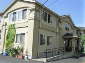 ２階建ての建物は一般の住宅のような家庭的な雰囲気。玄関には手すり付きのスロープが付いている。