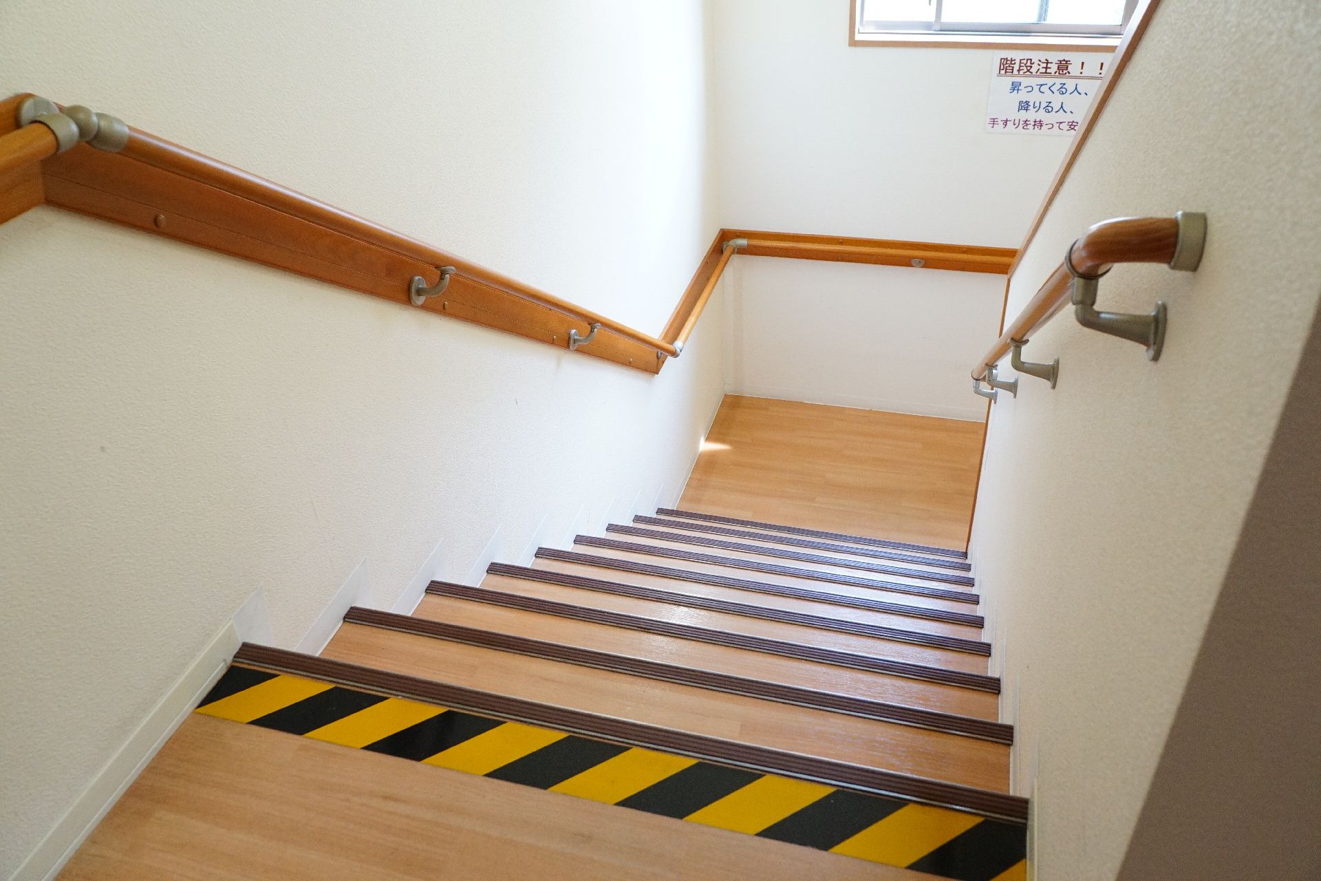 各段に滑り止めが設置され、大きな手すりが取り付けられている階段