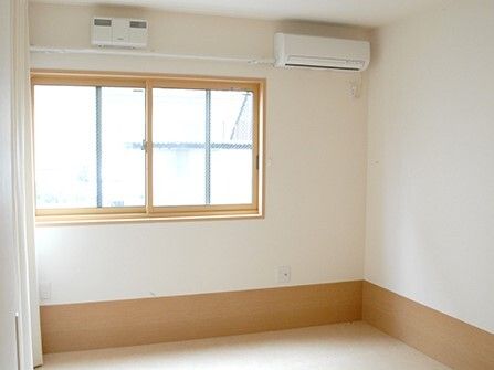 エアコン付きのシンプルな部屋には家具や家電は置かれていない。大きな窓があり明るい雰囲気。