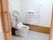 スライド式のドアが設置されたトイレは広く、便座にはふたがなく、背もたれも付いている。