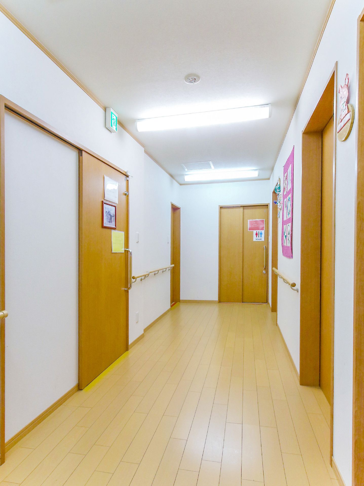 手でしっかりとつかみやすい形状の手すりが設置されている廊下